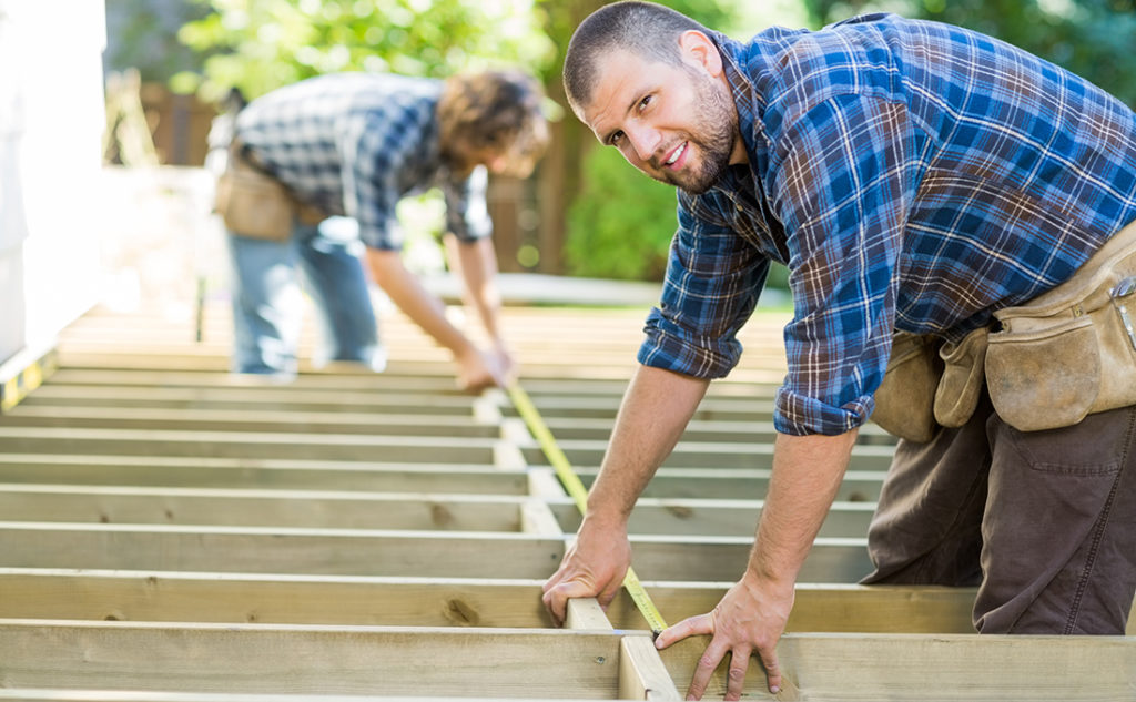 Two men building composite deck substructure