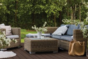 Beautiful green garden with wicker terrace furniture and trees