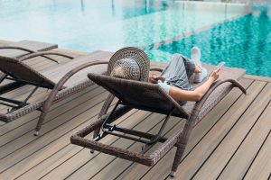 Woman sitting by a pool on a deck